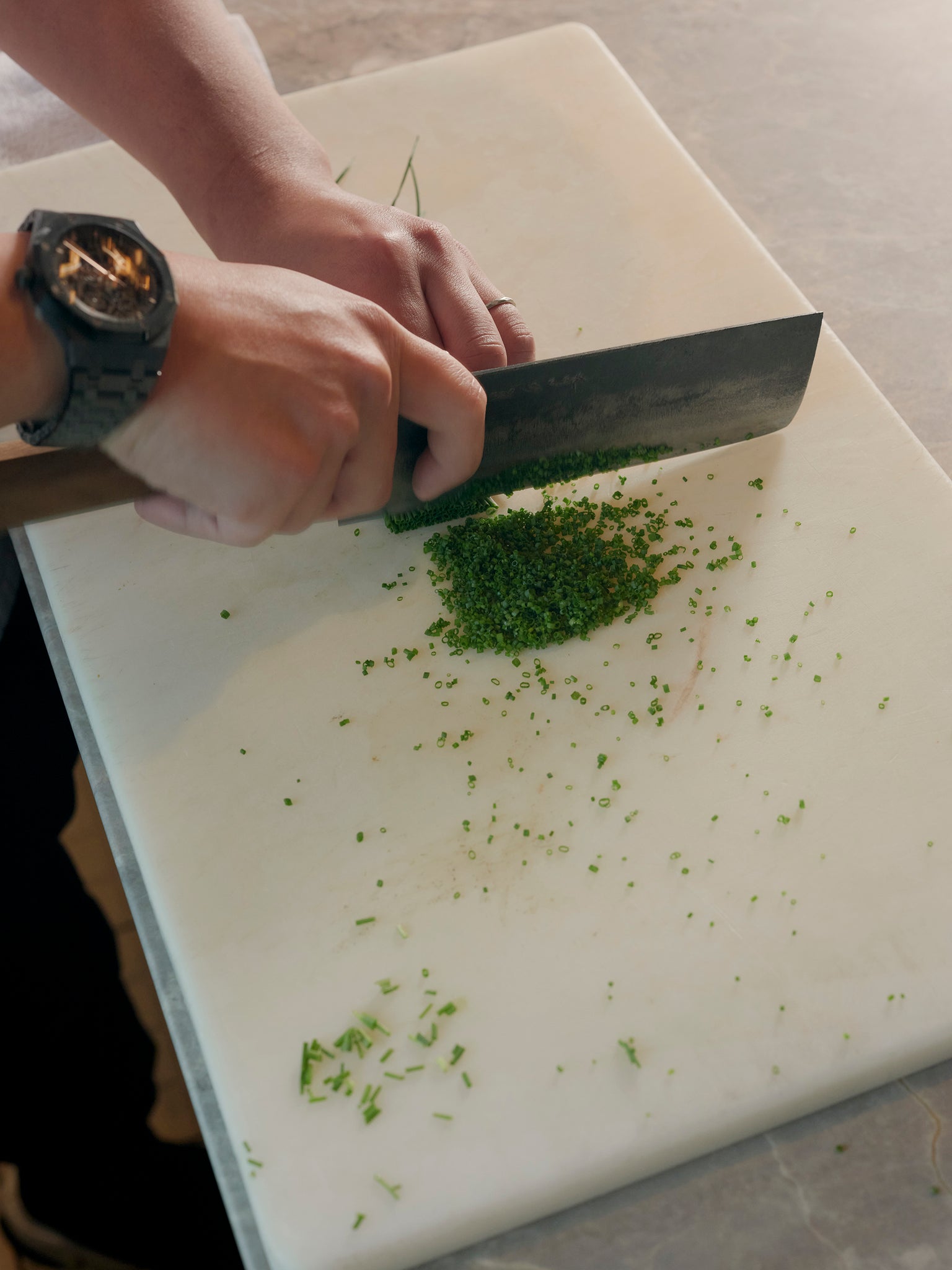 Vicky Cheng in Wing Restaurant, his new venture after VEA with his collection of chef's knives and a bunch of chopped chives on a white chopping board, interviewed by A Collected Man London