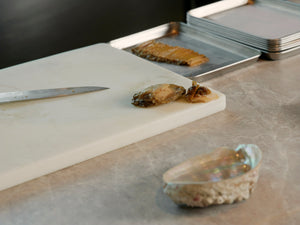 Vicky Cheng, chef and co-owner of Wing Restaurant with sliced abalone placed on a white chopping board with an abalone shell at the side, traditional Chinese cooking interview by A Collected Man London